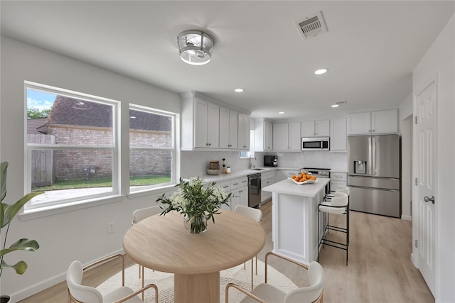 1503 Bamwick Dr, Houston, TX 77090 - kitchen featuring stainless steel appliances, light countertops, decorative backsplash, light wood-style flooring, and recessed lighting