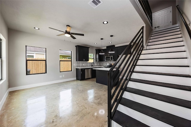 2407 Dolly Wright St, Houston, TX 77088 - kitchen featuring appliances with stainless steel finishes, dark cabinetry, a ceiling fan, light countertops, and tasteful backsplash