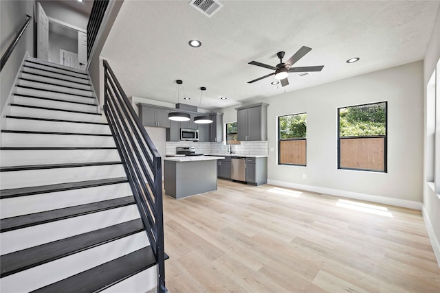 2409 Dolly Wright St, Houston, TX 77088 - kitchen with stainless steel appliances, gray cabinets, light countertops, backsplash, and recessed lighting