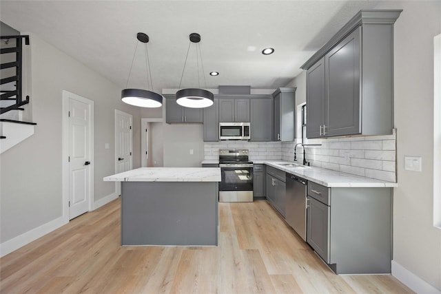 2409 Dolly Wright St, Houston, TX 77088 - kitchen featuring stainless steel appliances, gray cabinets, a kitchen island, light wood-style floors, and recessed lighting