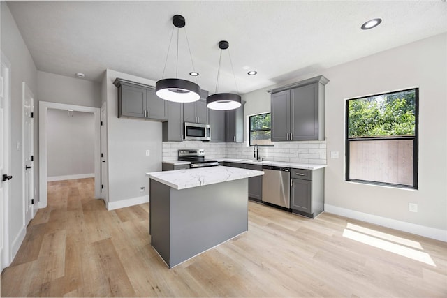 2409 Dolly Wright St, Houston, TX 77088 - kitchen with appliances with stainless steel finishes, gray cabinetry, decorative backsplash, light wood finished floors, and recessed lighting