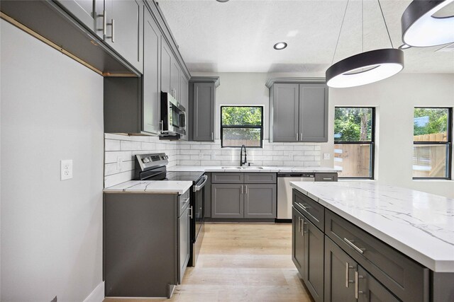 2409 Dolly Wright St, Houston, TX 77088 - kitchen with stainless steel appliances, gray cabinetry, decorative backsplash, and recessed lighting