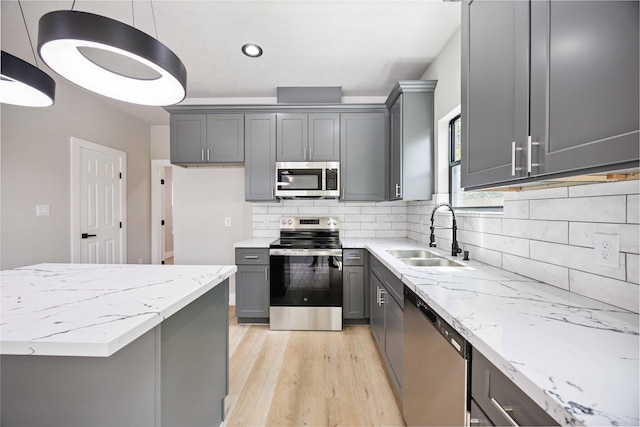 2409 Dolly Wright St, Houston, TX 77088 - kitchen featuring appliances with stainless steel finishes, gray cabinets, light wood-style flooring, tasteful backsplash, and recessed lighting