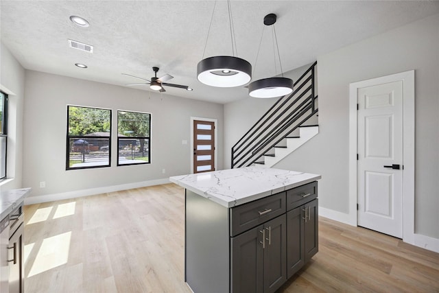 2409 Dolly Wright St, Houston, TX 77088 - kitchen featuring light wood-type flooring, a center island, hanging light fixtures, ceiling fan, and open floor plan