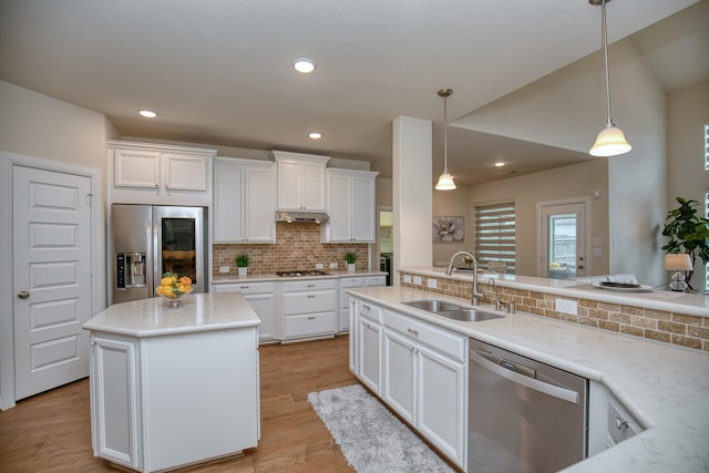 5506 Bellingen River Ln, Sugar Land, TX 77479 - kitchen with stainless steel appliances, tasteful backsplash, white cabinets, pendant lighting, and light wood-style floors