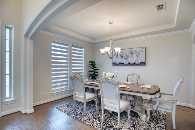 5506 Bellingen River Ln, Sugar Land, TX 77479 - dining room featuring a raised ceiling, arched walkways, a chandelier, wood finished floors, and crown molding