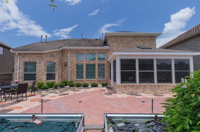 5506 Bellingen River Ln, Sugar Land, TX 77479 - back of property featuring a patio, brick siding, a sunroom, and roof with shingles