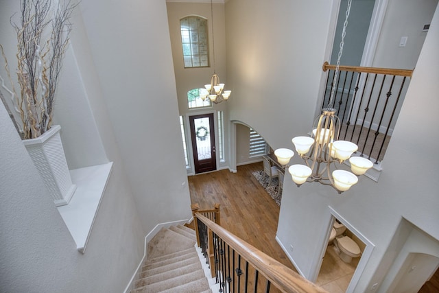 5506 Bellingen River Ln, Sugar Land, TX 77479 - foyer featuring a chandelier, a towering ceiling, arched walkways, wood finished floors, and stairs