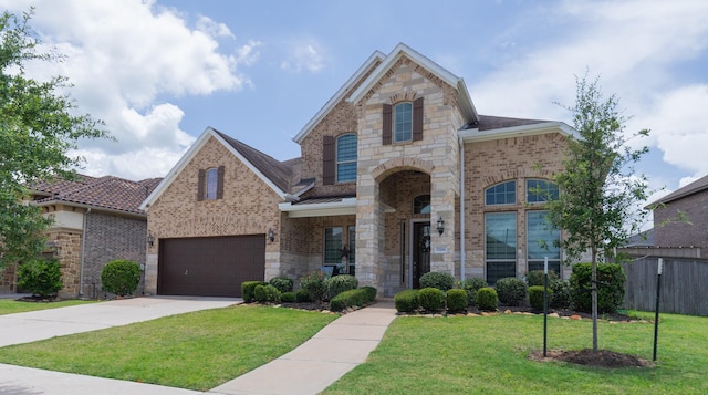 5506 Bellingen River Ln, Sugar Land, TX 77479 - french country inspired facade with driveway, a garage, stone siding, and brick siding