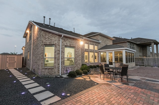 5506 Bellingen River Ln, Sugar Land, TX 77479 - back of property featuring a patio area, a gate, brick siding, and a sunroom