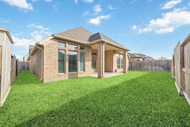 13727 Pedernales Ct, Cypress, TX 77429 - rear view of house with brick siding, a shingled roof, a patio area, and a fenced backyard