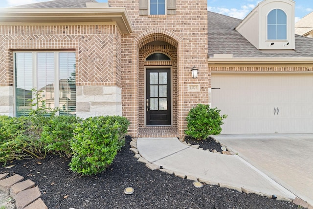 13727 Pedernales Ct, Cypress, TX 77429 - doorway to property featuring brick siding, roof with shingles, an attached garage, and concrete driveway