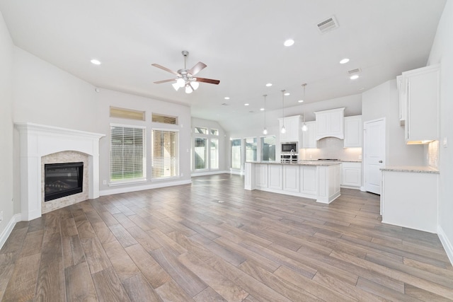 13727 Pedernales Ct, Cypress, TX 77429 - unfurnished living room with ceiling fan, light wood-type flooring, recessed lighting, and a glass covered fireplace