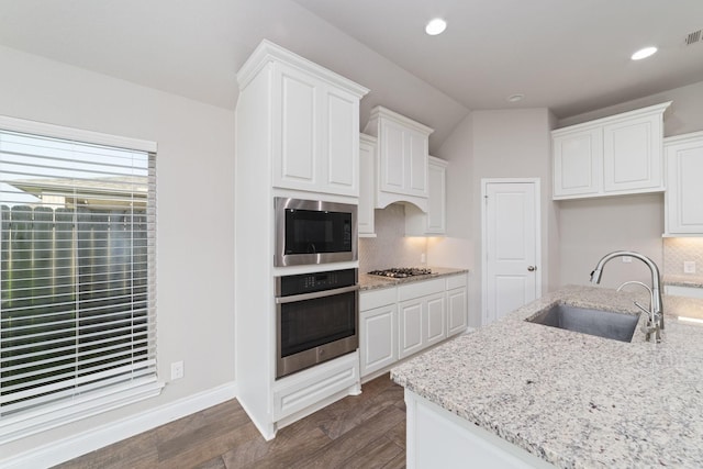13727 Pedernales Ct, Cypress, TX 77429 - kitchen with stainless steel appliances, tasteful backsplash, dark wood-type flooring, light stone countertops, and white cabinets