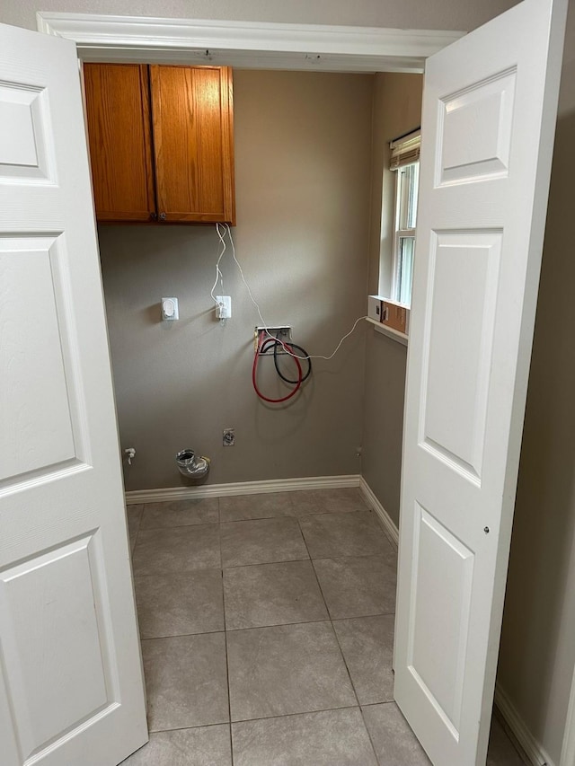 318 N 4th St, Alvin, TX 77511 - laundry area with washer hookup, cabinet space, and light tile patterned flooring