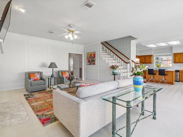 4614 Jamaica Dr, Sugar Land, TX 77479 - living room with a decorative wall, stairway, a ceiling fan, and a textured ceiling