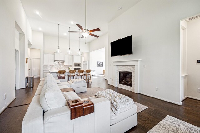 32311 Noble Creek Dr, Conroe, TX 77385 - living area featuring a ceiling fan, a towering ceiling, a stone fireplace, dark wood-style floors, and recessed lighting