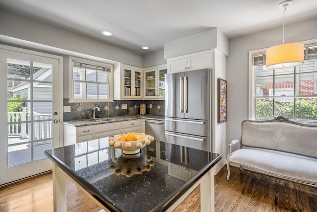 2717 University Blvd, Houston, TX 77005 - kitchen featuring appliances with stainless steel finishes, glass insert cabinets, white cabinetry, light wood finished floors, and backsplash