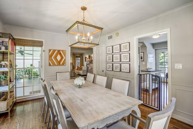2717 University Blvd, Houston, TX 77005 - dining room featuring dark wood-style flooring, a chandelier, crown molding, and a decorative wall