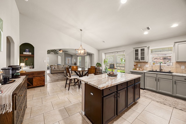 15003 Moonlight Mist Dr, Humble, TX 77346 - kitchen with dishwasher, lofted ceiling, glass insert cabinets, a kitchen island, and light tile patterned floors