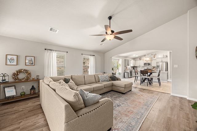 15003 Moonlight Mist Dr, Humble, TX 77346 - living room with arched walkways, healthy amount of natural light, light wood-style floors, a ceiling fan, and vaulted ceiling