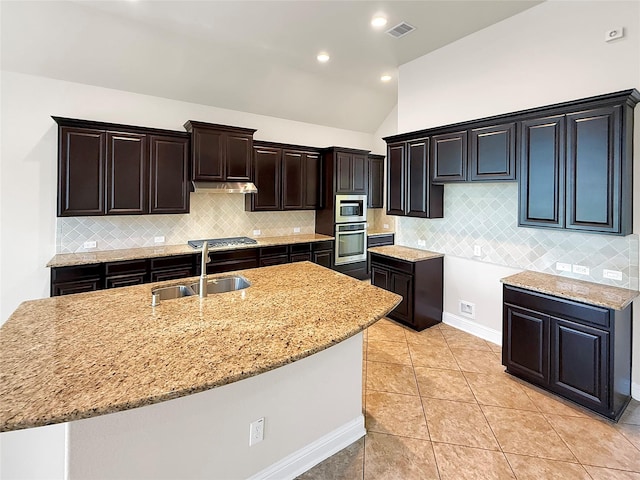 18614 Rimini Ridge Ct, Cypress, TX 77429 - kitchen featuring appliances with stainless steel finishes, light stone countertops, lofted ceiling, tasteful backsplash, and light tile patterned floors