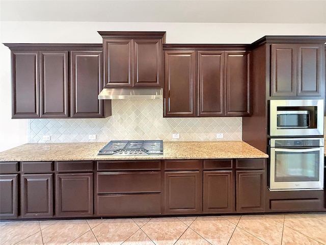 18614 Rimini Ridge Ct, Cypress, TX 77429 - kitchen with appliances with stainless steel finishes, under cabinet range hood, backsplash, and dark brown cabinets