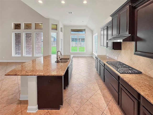 18614 Rimini Ridge Ct, Cypress, TX 77429 - kitchen with light tile patterned floors, stainless steel gas stovetop, vaulted ceiling, recessed lighting, and decorative backsplash