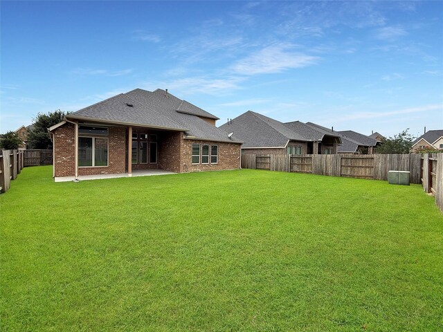 18614 Rimini Ridge Ct, Cypress, TX 77429 - rear view of property featuring a fenced backyard, roof with shingles, brick siding, and a patio area