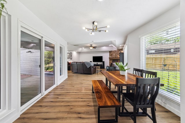 1818 Berryfield Dr, Houston, TX 77077 - dining space with a large fireplace, healthy amount of natural light, wood finished floors, and a chandelier