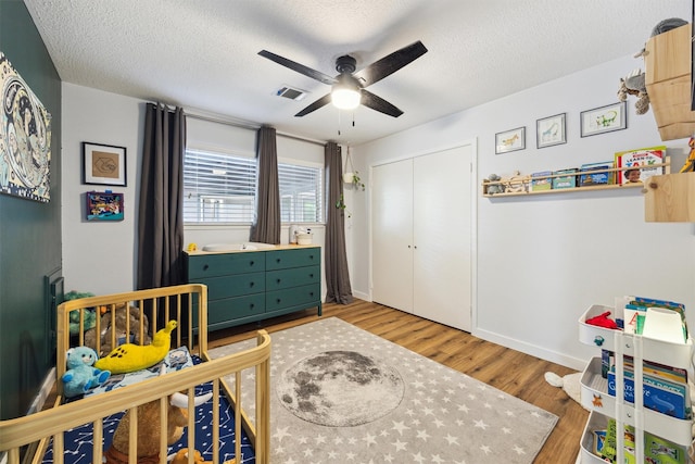 1818 Berryfield Dr, Houston, TX 77077 - bedroom featuring light wood finished floors, a textured ceiling, a closet, and a ceiling fan
