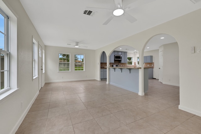 519 N Shady Ln, La Porte, TX 77571 - kitchen with stainless steel microwave, a ceiling fan, a breakfast bar area, open floor plan, and recessed lighting