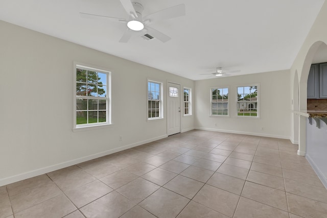 519 N Shady Ln, La Porte, TX 77571 - spare room with a ceiling fan, healthy amount of natural light, light tile patterned floors, and arched walkways