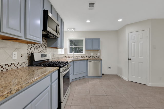 519 N Shady Ln, La Porte, TX 77571 - kitchen featuring appliances with stainless steel finishes, decorative backsplash, light stone counters, recessed lighting, and light tile patterned floors