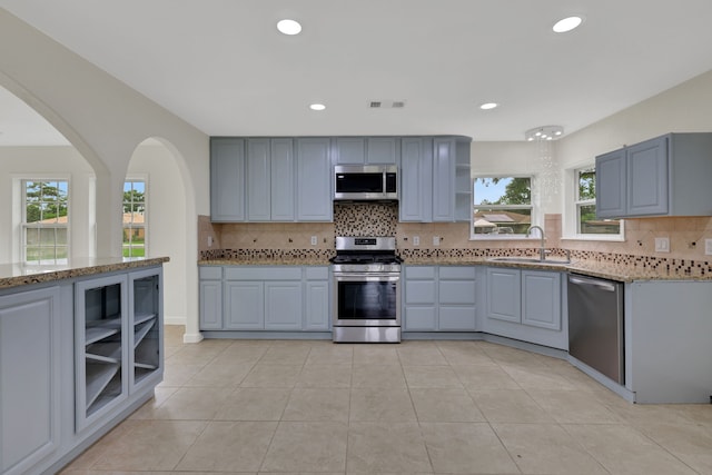 519 N Shady Ln, La Porte, TX 77571 - kitchen featuring appliances with stainless steel finishes, open shelves, light stone countertops, backsplash, and recessed lighting