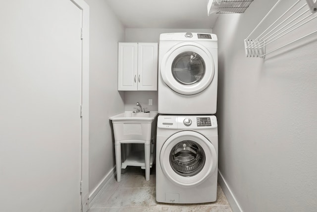 7539 Santa Fe Dr, Houston, TX 77061 - laundry area featuring stacked washer and clothes dryer and cabinet space