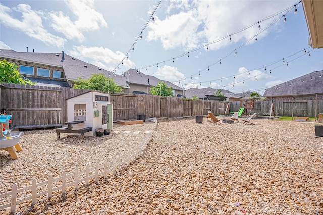 4107 Rainflower Ct, Fulshear, TX 77441 - fenced backyard with a fire pit and an outbuilding