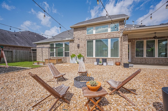 4107 Rainflower Ct, Fulshear, TX 77441 - rear view of property featuring brick siding, an outdoor fire pit, a patio, and roof with shingles