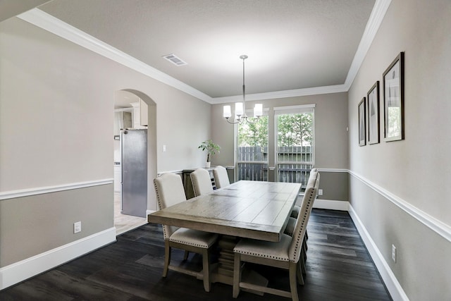 19222 Bullard Creek Dr, Cypress, TX 77433 - dining space with a chandelier, arched walkways, crown molding, and dark wood finished floors