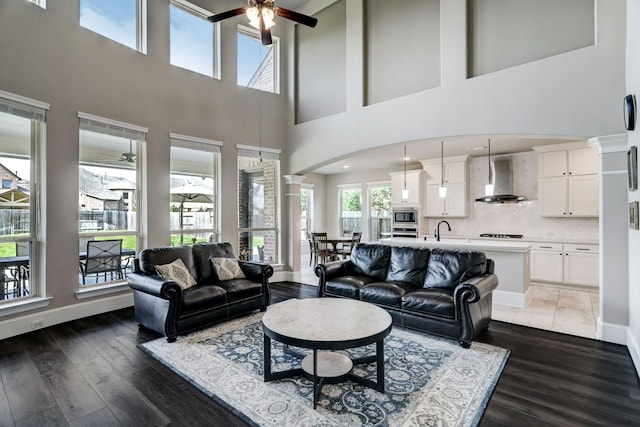 19222 Bullard Creek Dr, Cypress, TX 77433 - living room with ceiling fan, arched walkways, wood finished floors, and a high ceiling
