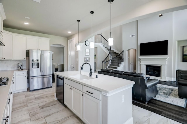 19222 Bullard Creek Dr, Cypress, TX 77433 - kitchen with stainless steel refrigerator with ice dispenser, arched walkways, dishwashing machine, open floor plan, and recessed lighting