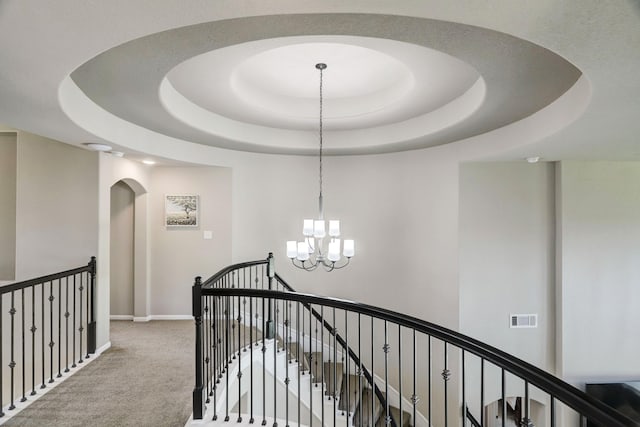 19222 Bullard Creek Dr, Cypress, TX 77433 - hall featuring an upstairs landing, a chandelier, carpet, arched walkways, and a raised ceiling