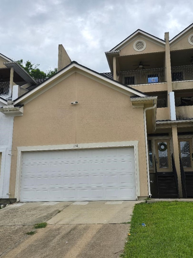 176 Capetown, Conroe, TX 77356 - view of front of property featuring a balcony, driveway, stucco siding, and a garage