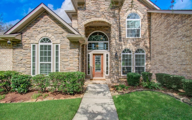 2512 Eagle Post Dr, Conroe, TX 77304 - doorway to property featuring stone siding and a lawn