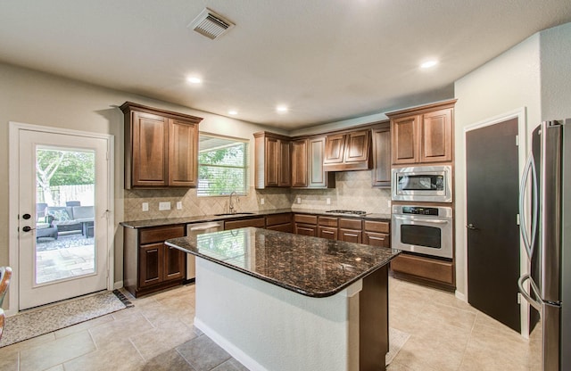 2512 Eagle Post Dr, Conroe, TX 77304 - kitchen with stainless steel appliances, plenty of natural light, backsplash, dark stone countertops, and recessed lighting