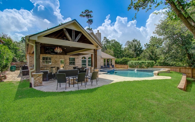 2512 Eagle Post Dr, Conroe, TX 77304 - back of property with a chimney, a patio area, a fenced backyard, and a pool with connected hot tub