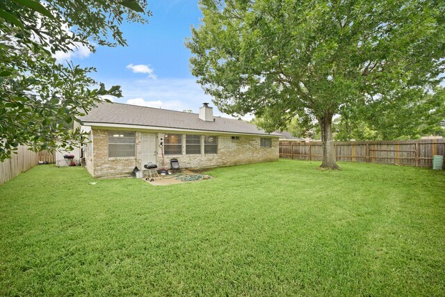 411 Pickford Dr, Katy, TX 77450 - rear view of property featuring a fenced backyard, a chimney, and brick siding