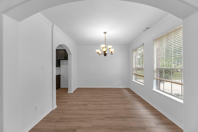 5918 Mahogany Way, Magnolia, TX 77354 - empty room featuring crown molding, a chandelier, light wood-type flooring, and arched walkways