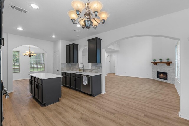 5918 Mahogany Way, Magnolia, TX 77354 - kitchen with a chandelier, dishwasher, arched walkways, light countertops, and light wood-style flooring