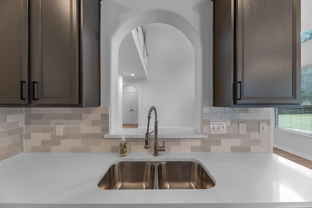 5918 Mahogany Way, Magnolia, TX 77354 - kitchen with dark brown cabinets, arched walkways, light countertops, and backsplash